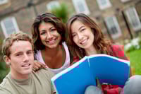 Happy group of students with a notebook outdoors
