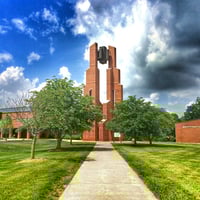 Taylor University building surrounded by green trees, grass and blue skies