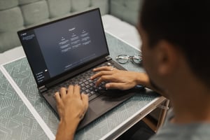 Photo of student sitting at a laptop using ChatGPT