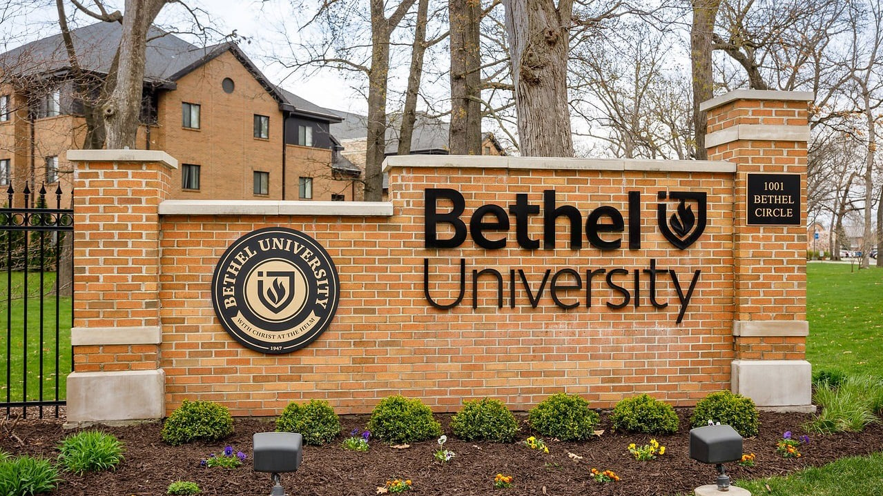 Bethel University sign in front of brick buildings and trees